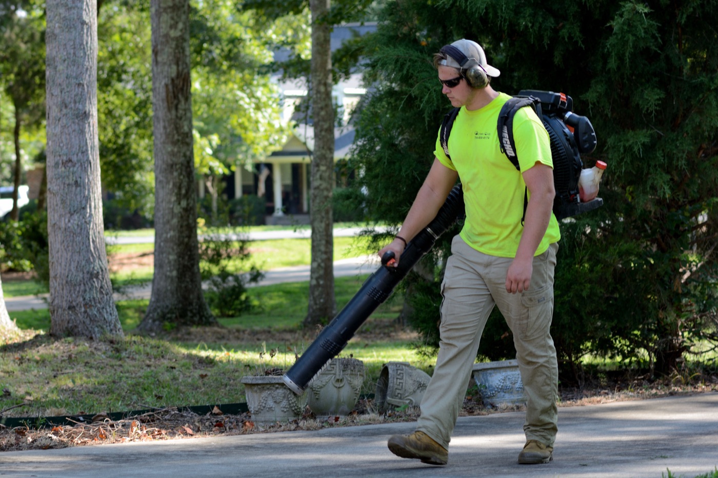 GreenEdge crew member cleaning up a yard